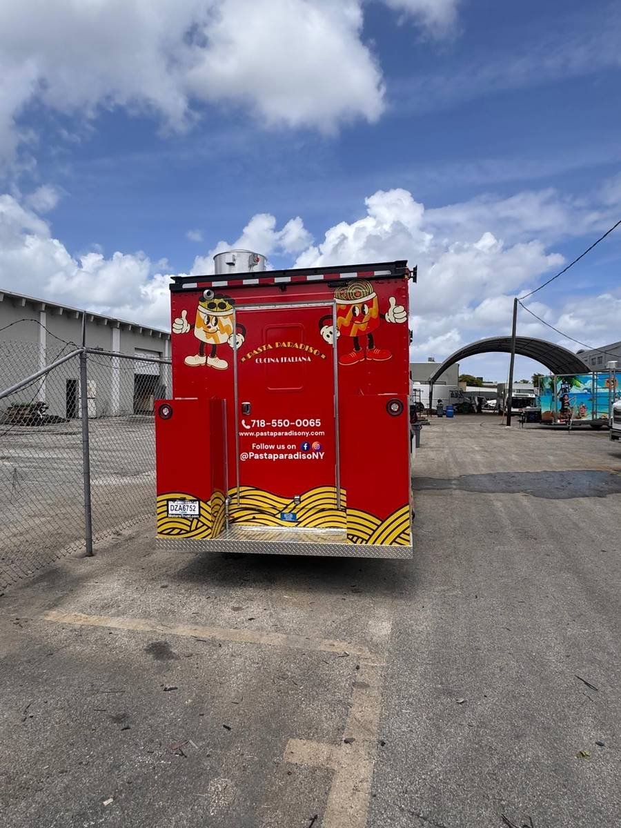 Rear view of the Pasta Paradiso food truck showing the Pasty mascot artwork and pasta-wave graphics on the back doors.